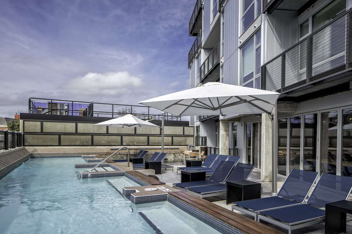 Amenities include a swimming pool and expansive sun deck, outdoor “living rooms” with grilling stations and outdoor kitchens, and a resident lounge with a kitchen, bar, private dining room, pool table, and media center. 